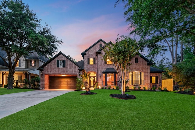 view of front of property featuring brick siding, a garage, concrete driveway, and a lawn