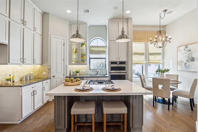 4404 Dickson St Unit B, Houston, TX 77007 - kitchen featuring stainless steel appliances, backsplash, dark wood-style flooring, a breakfast bar area, and recessed lighting