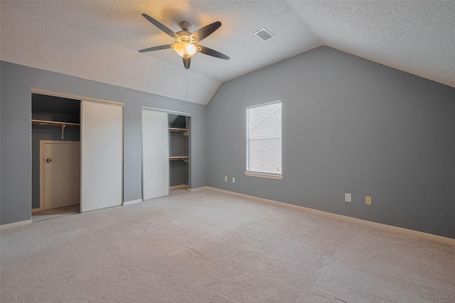 9911 Villa Verde Dr, Houston, TX 77064 - unfurnished bedroom with lofted ceiling, two closets, a textured ceiling, light carpet, and ceiling fan