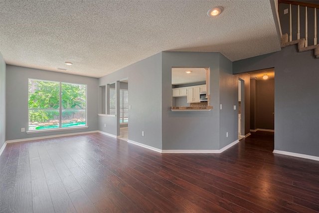 9911 Villa Verde Dr, Houston, TX 77064 - unfurnished living room with a textured ceiling, baseboards, dark wood finished floors, and stairway