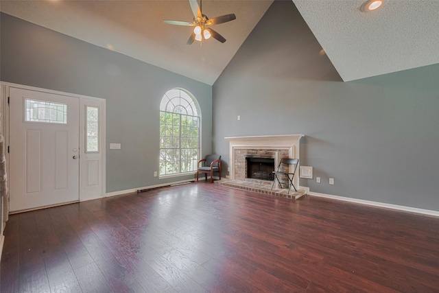 9911 Villa Verde Dr, Houston, TX 77064 - unfurnished living room with high vaulted ceiling, a ceiling fan, a brick fireplace, wood finished floors, and baseboards