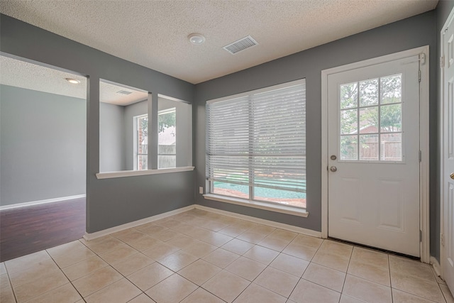 9911 Villa Verde Dr, Houston, TX 77064 - doorway featuring a textured ceiling, light tile patterned floors, and baseboards