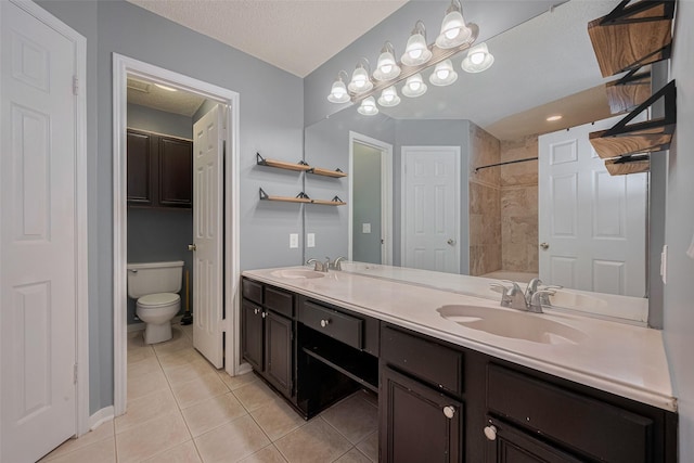 9911 Villa Verde Dr, Houston, TX 77064 - bathroom featuring tile patterned flooring, toilet, double vanity, a shower, and a textured ceiling