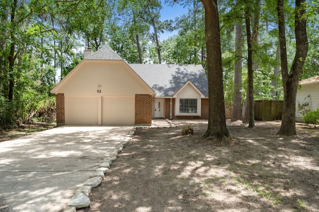 52 S High Oaks Cir, The Woodlands, TX 77380 - view of front of home with a garage, concrete driveway, brick siding, and fence