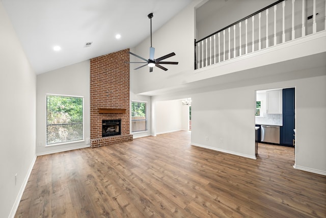 52 S High Oaks Cir, The Woodlands, TX 77380 - unfurnished living room featuring a ceiling fan, a fireplace, wood finished floors, a chandelier, and high vaulted ceiling