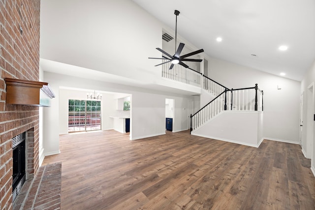 52 S High Oaks Cir, The Woodlands, TX 77380 - unfurnished living room featuring a brick fireplace, high vaulted ceiling, a chandelier, wood finished floors, and baseboards