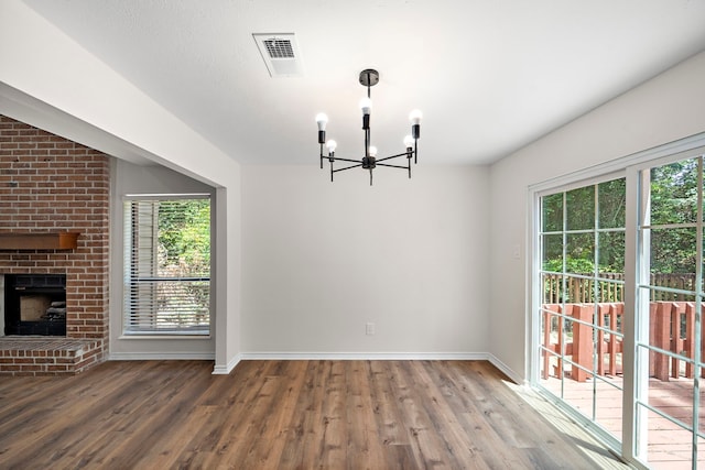 52 S High Oaks Cir, The Woodlands, TX 77380 - unfurnished dining area featuring a chandelier, wood finished floors, baseboards, and a fireplace