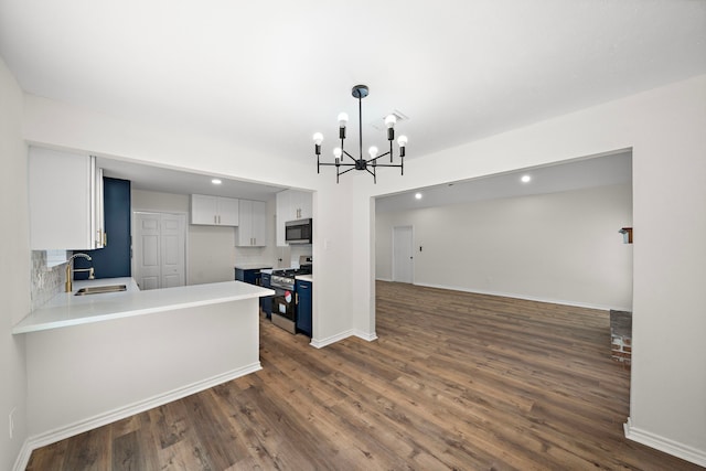 52 S High Oaks Cir, The Woodlands, TX 77380 - kitchen featuring appliances with stainless steel finishes, dark wood-type flooring, a sink, a peninsula, and a chandelier