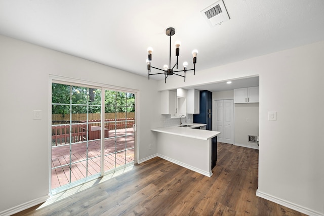 52 S High Oaks Cir, The Woodlands, TX 77380 - kitchen featuring a sink, a chandelier, light countertops, a peninsula, and white cabinetry