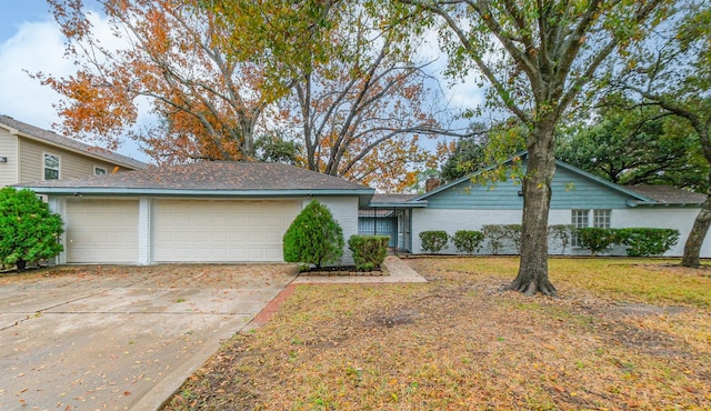 view of front of home with an attached garage, driveway, a chimney, and brick siding