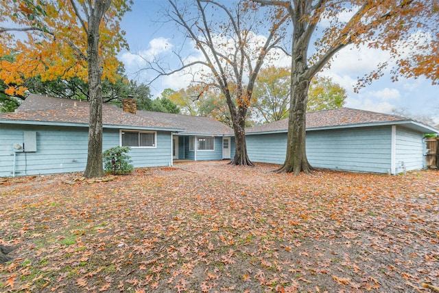 rear view of property featuring a chimney