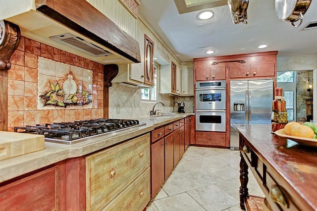 kitchen with stainless steel appliances, a sink, light countertops, decorative backsplash, and recessed lighting