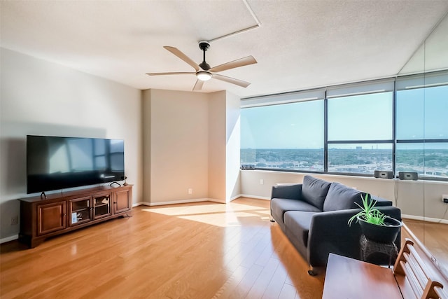 living area with ceiling fan, wood finished floors, and baseboards