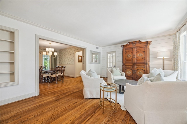 2618 Sunset Blvd, West University Place, TX 77005 - living room with light wood-style flooring, a chandelier, ornamental molding, baseboards, and wallpapered walls