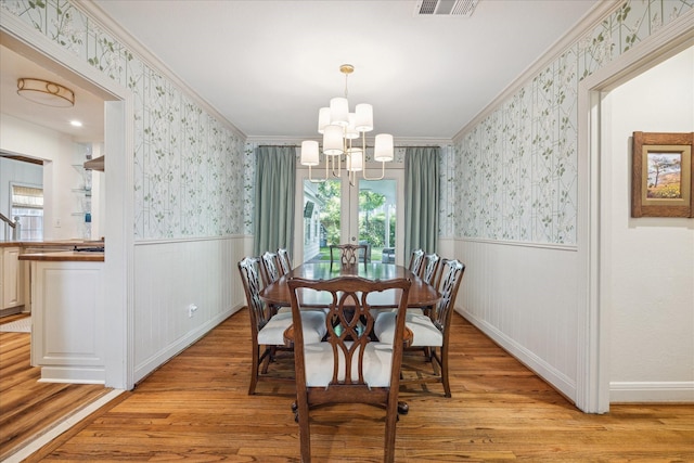 2618 Sunset Blvd, West University Place, TX 77005 - dining room featuring wallpapered walls, wainscoting, a chandelier, light wood finished floors, and plenty of natural light