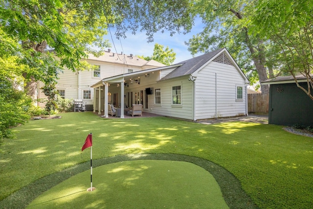 2618 Sunset Blvd, West University Place, TX 77005 - back of property with a putting green, a patio area, roof with shingles, and an outbuilding
