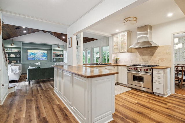 2618 Sunset Blvd, West University Place, TX 77005 - kitchen featuring wall chimney exhaust hood, luxury range, butcher block countertops, a sink, and light wood finished floors