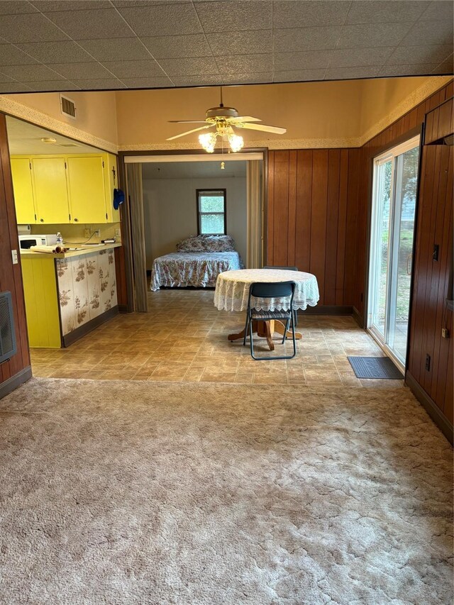 104 Crooked Creek Dr, Sheridan, TX 77475 - dining area with light colored carpet, baseboards, wooden walls, and a ceiling fan