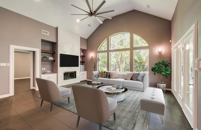 14834 Plantation Oak Dr, Houston, TX 77068 - living area with ceiling fan, high vaulted ceiling, built in features, dark tile patterned flooring, and a glass covered fireplace