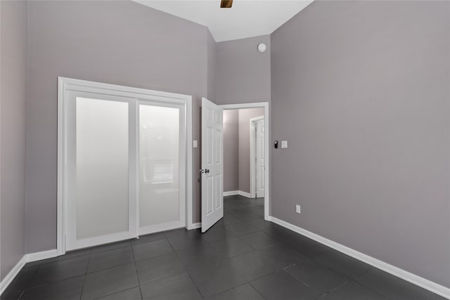 14834 Plantation Oak Dr, Houston, TX 77068 - unfurnished bedroom with baseboards, dark tile patterned floors, and ceiling fan