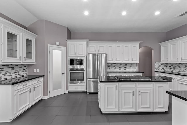14834 Plantation Oak Dr, Houston, TX 77068 - kitchen featuring appliances with stainless steel finishes, dark countertops, tasteful backsplash, white cabinets, and recessed lighting