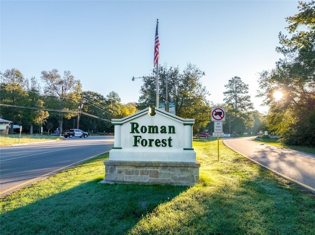 community / neighborhood sign featuring a lawn