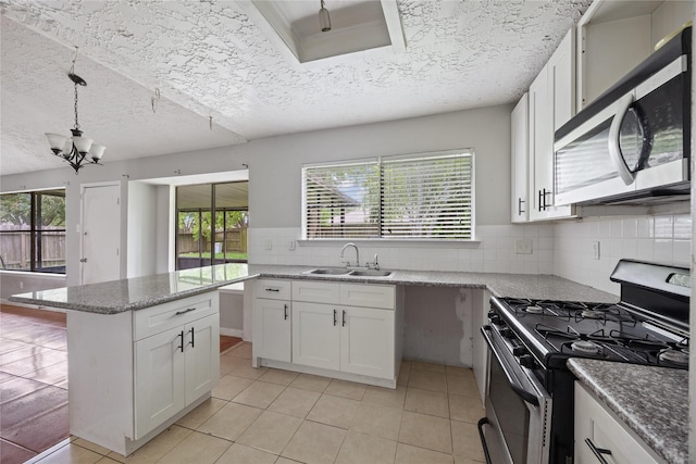kitchen featuring stainless steel appliances, a sink, white cabinetry, backsplash, and a center island