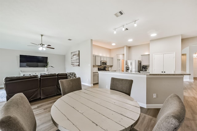 20810 Oak Rain Ct, Katy, TX 77449 - dining room featuring light wood-style floors, baseboards, ceiling fan, arched walkways, and lofted ceiling