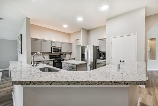20810 Oak Rain Ct, Katy, TX 77449 - kitchen with appliances with stainless steel finishes, gray cabinetry, a sink, wood finished floors, and baseboards