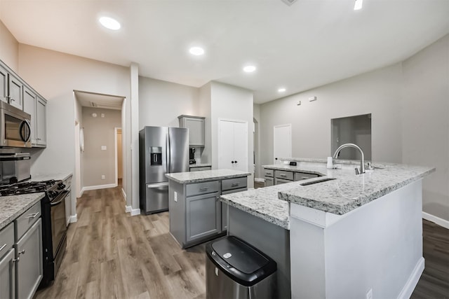 20810 Oak Rain Ct, Katy, TX 77449 - kitchen featuring appliances with stainless steel finishes, a spacious island, gray cabinets, a sink, and recessed lighting