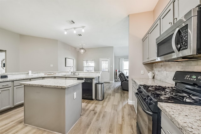 20810 Oak Rain Ct, Katy, TX 77449 - kitchen featuring black appliances, a sink, light wood-style floors, backsplash, and gray cabinetry