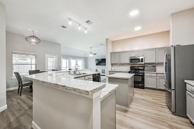 20810 Oak Rain Ct, Katy, TX 77449 - kitchen with black appliances, a large island, a sink, and plenty of natural light