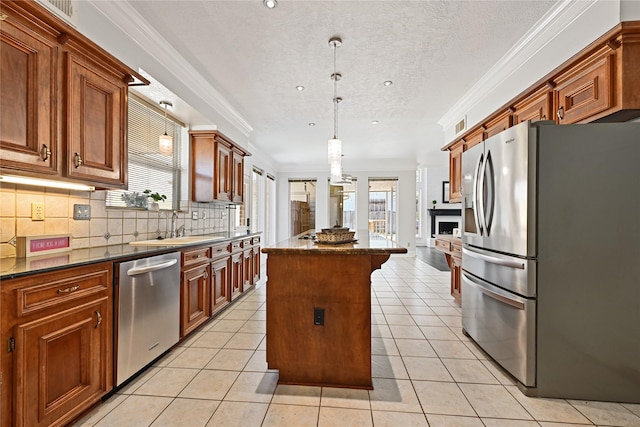 17414 Naremore Ct, Spring, TX 77379 - kitchen with appliances with stainless steel finishes, a kitchen island, a sink, healthy amount of natural light, and a textured ceiling