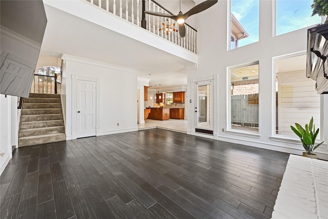 17414 Naremore Ct, Spring, TX 77379 - unfurnished living room with a towering ceiling, stairs, wood finished floors, baseboards, and ceiling fan