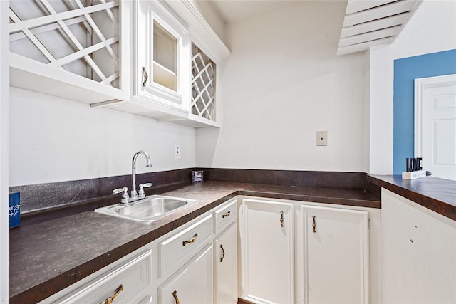 17414 Naremore Ct, Spring, TX 77379 - kitchen featuring a sink, dark countertops, white cabinets, and glass insert cabinets