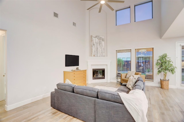 2327 Partridgeberry Ln, Katy, TX 77494 - living room with ceiling fan, a towering ceiling, wood finished floors, baseboards, and healthy amount of natural light
