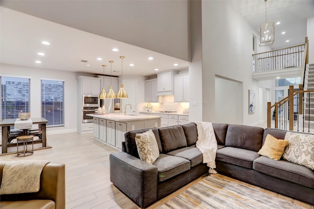 2327 Partridgeberry Ln, Katy, TX 77494 - living area with stairs, recessed lighting, light wood finished floors, baseboards, and a high ceiling