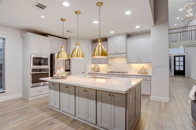 2327 Partridgeberry Ln, Katy, TX 77494 - kitchen featuring stainless steel appliances, a sink, light wood finished floors, light countertops, and recessed lighting