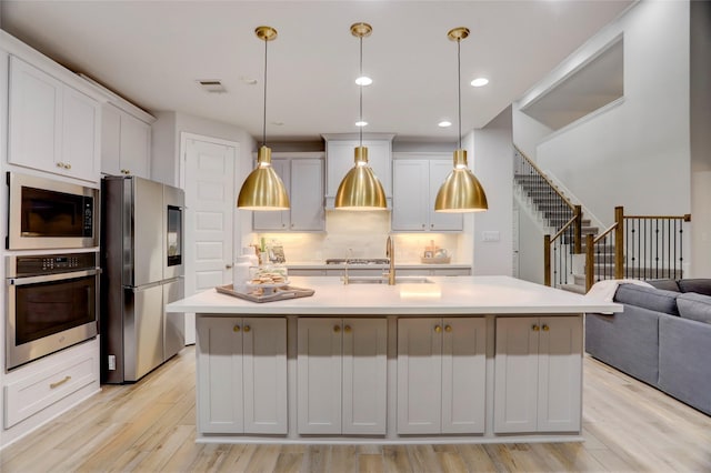2327 Partridgeberry Ln, Katy, TX 77494 - kitchen with appliances with stainless steel finishes, a sink, light countertops, light wood-style floors, and recessed lighting