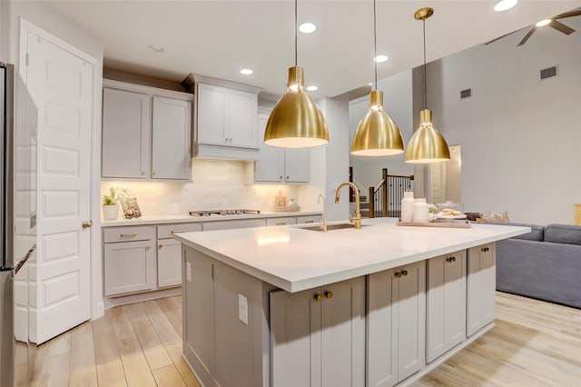 2327 Partridgeberry Ln, Katy, TX 77494 - kitchen featuring open floor plan, stovetop, a sink, freestanding refrigerator, and light wood finished floors