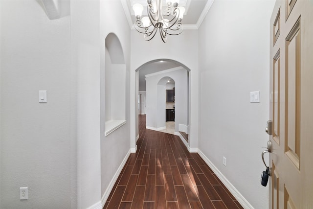21606 Hansom Dr, Porter, TX 77365 - corridor featuring a chandelier, arched walkways, ornamental molding, baseboards, and dark wood finished floors