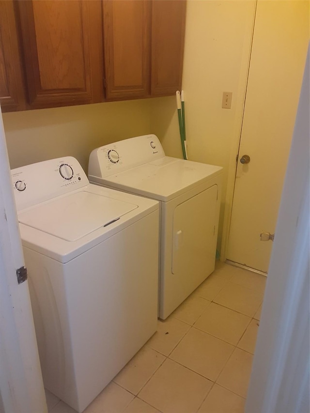4927 Algernon Dr, Spring, TX 77373 - clothes washing area featuring washer and clothes dryer, light tile patterned floors, and cabinet space