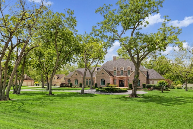 4323 Colony W Dr, Richmond, TX 77406 - french country style house with a front yard, a chimney, and stone siding