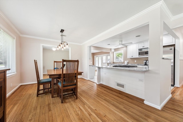 1803 Latexo Dr, Houston, TX 77018 - dining area featuring light wood finished floors, baseboards, ornamental molding, ceiling fan, and a chandelier