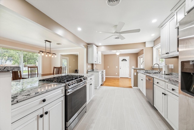 1803 Latexo Dr, Houston, TX 77018 - kitchen with stainless steel appliances, ceiling fan, light stone countertops, healthy amount of natural light, and recessed lighting