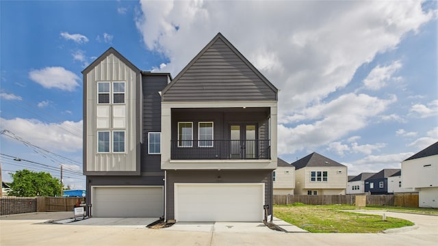 2710 Jensen Creek Ln, Houston, TX 77026 - view of front of house featuring board and batten siding, a garage, concrete driveway, and a residential view
