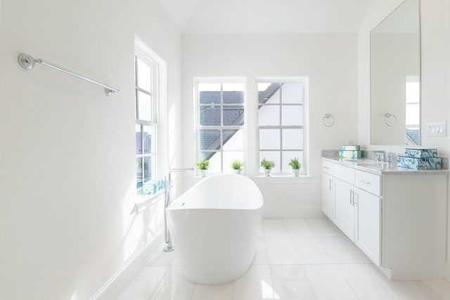 5304 S Capitol St, Houston, TX 77023 - bathroom featuring baseboards, a freestanding tub, vanity, and tile patterned floors
