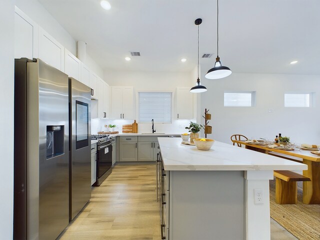 5914 Eastwood St, Houston, TX 77021 - kitchen with stainless steel appliances, a kitchen island, light stone counters, recessed lighting, and gray cabinets