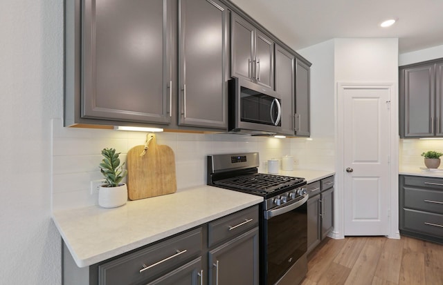25701 Damask Dr, Magnolia, TX 77355 - kitchen with stainless steel appliances, light wood-type flooring, backsplash, light countertops, and recessed lighting