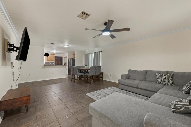 1314 Robert St, Baytown, TX 77521 - living area with ornamental molding, dark tile patterned floors, ceiling fan, and baseboards